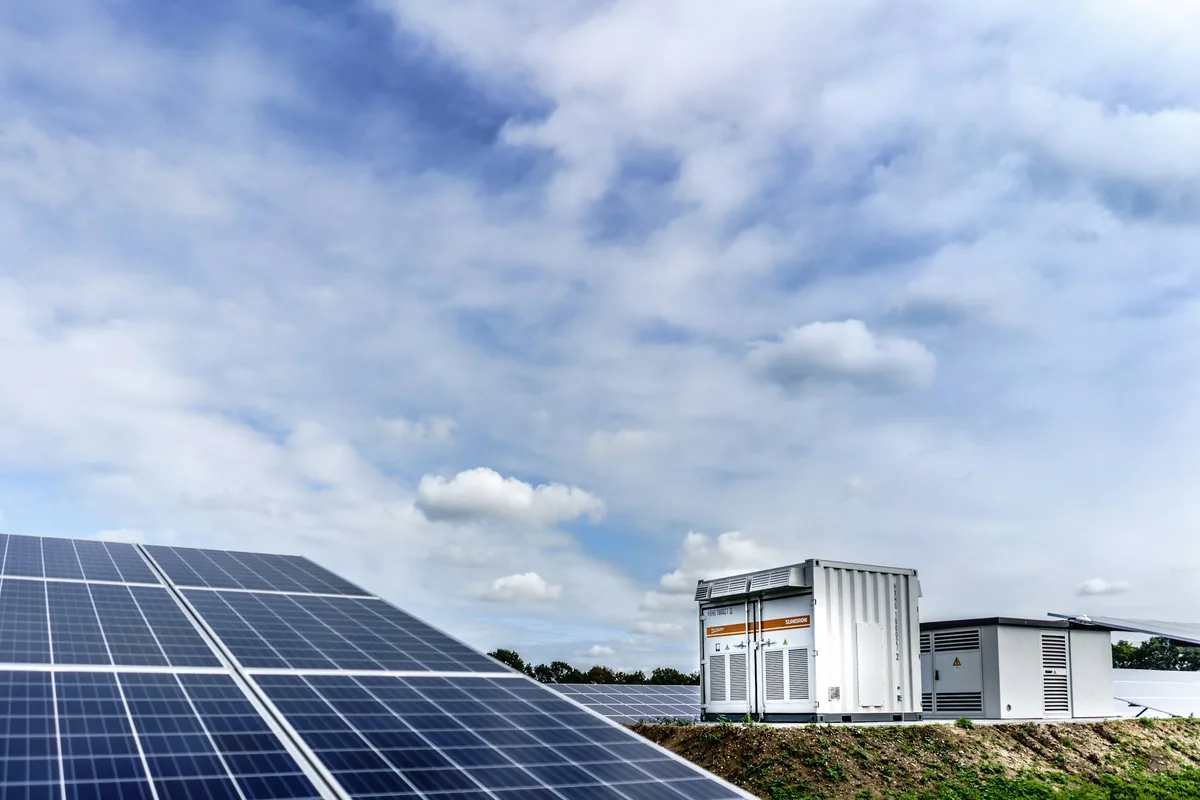 Battery storage containers beside a solar array