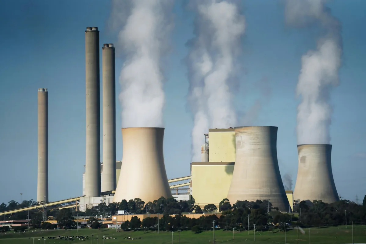 Thermal power station with cooling towers and chimney stacks